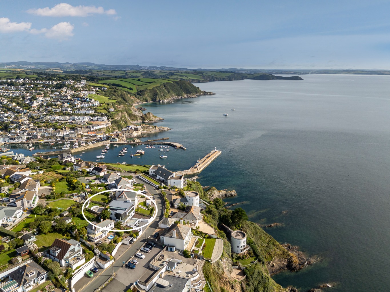 A striking four-bedroom coastal home with spectacular sea views, parking & landscaped gardens